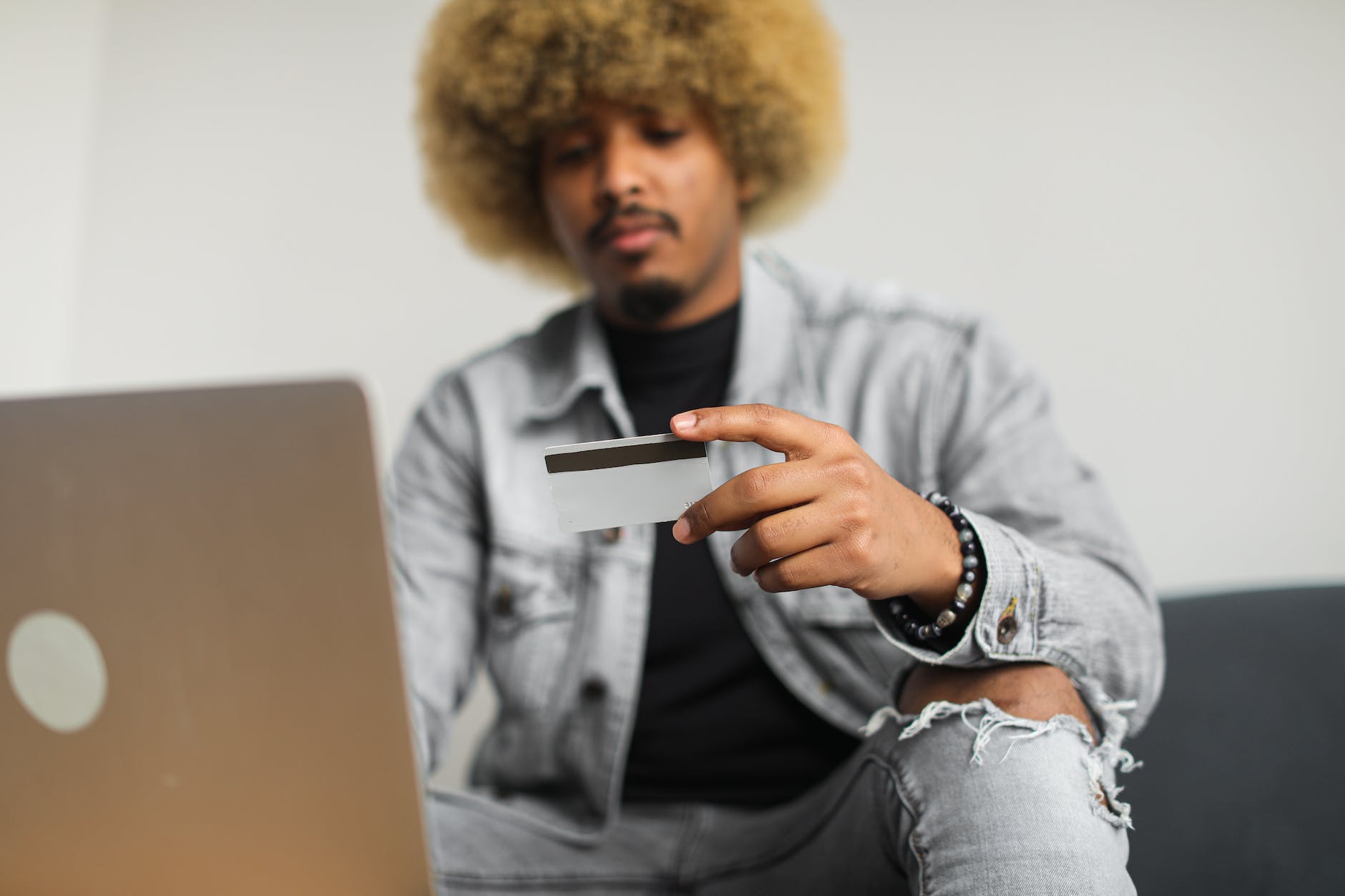 a man with an afro hair holding a credit card
