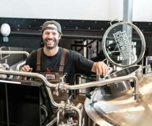 happily smiling man standing near gray bars