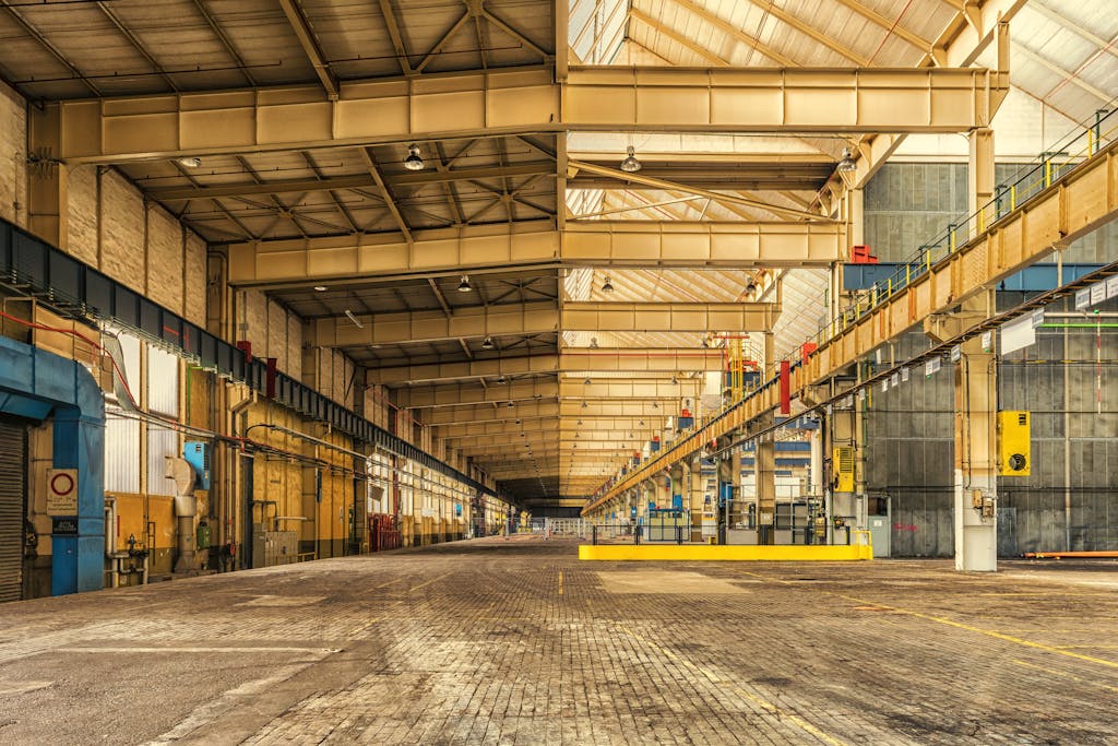 Expansive interior of an industrial warehouse showing steel beams, high ceilings, and ample space.