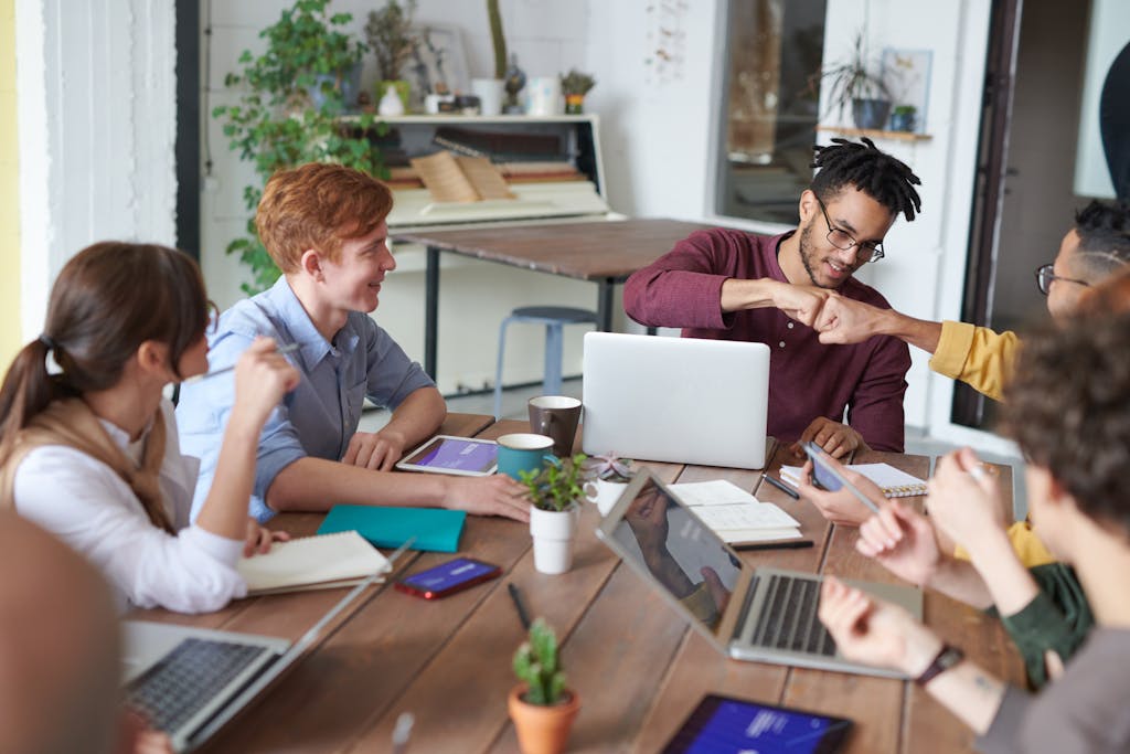 A diverse group of young professionals brainstorming around a table in a modern office environment. Teams using multi-tenant-intercom-system